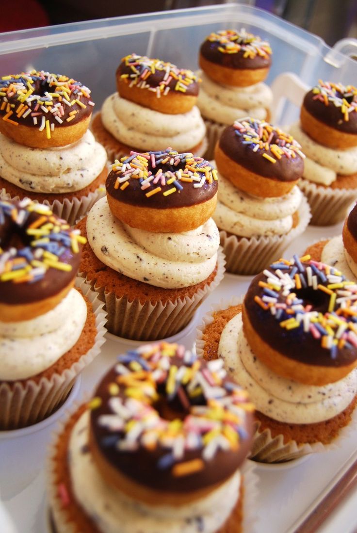 cupcakes with frosting and sprinkles are arranged on a tray