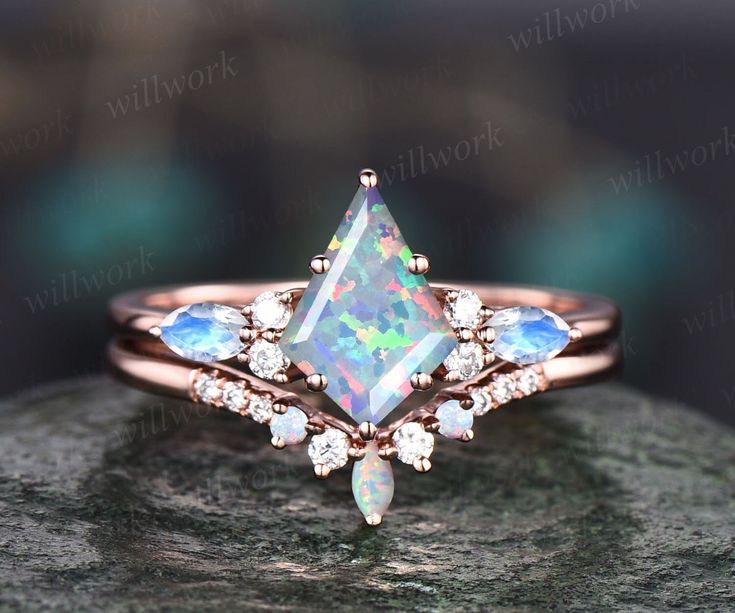 an opal and diamond ring on top of a rock