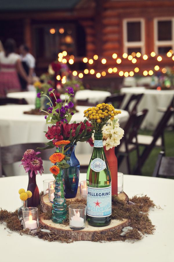 there are many vases with flowers in them on the table at this wedding reception