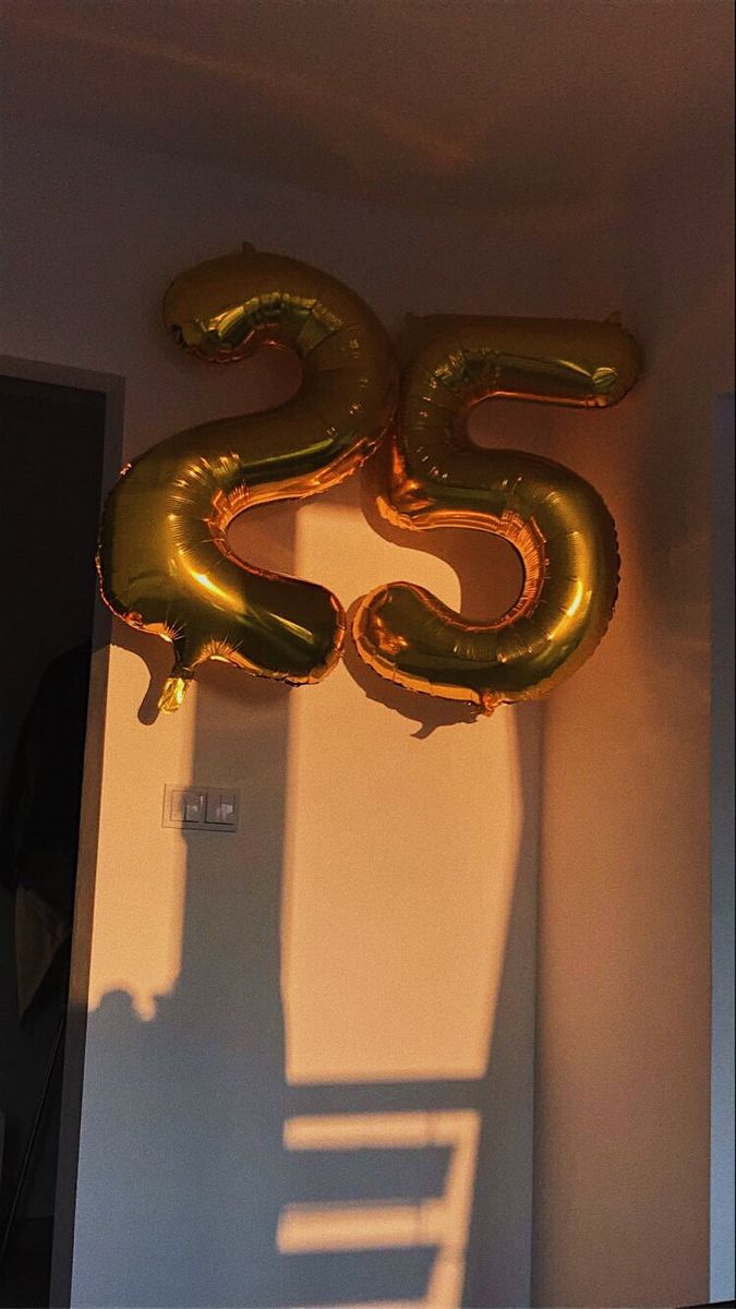 the number twenty five balloon is hanging on the wall in front of the door to the room