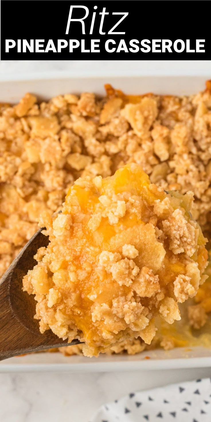 a casserole dish filled with pineapple crumbles and topped with a wooden spoon