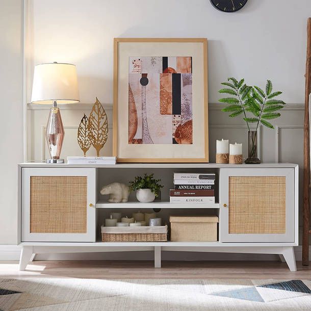 a white entertainment center with wicker baskets on it's sides and a clock above it