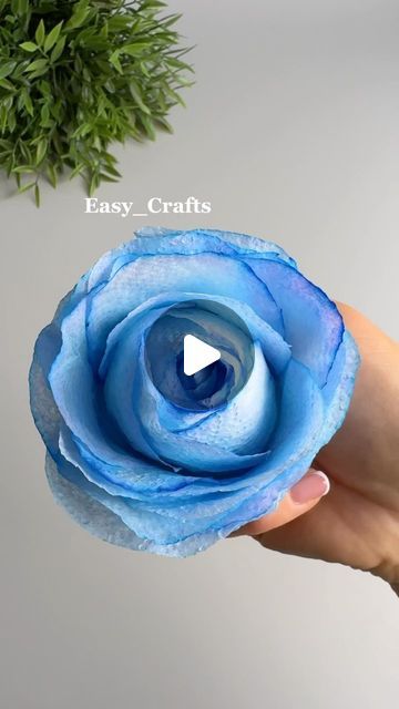 a hand holding a blue flower with the words easy crafts on it