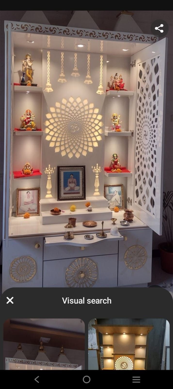 the inside of a cabinet with lights and pictures on it's shelves, including buddha statues