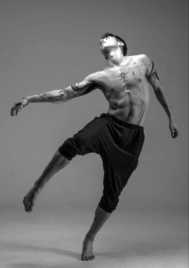 a man with tattoos on his body doing a dance move