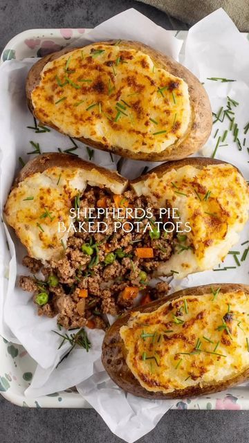 three baked potatoes with meat and herbs on top