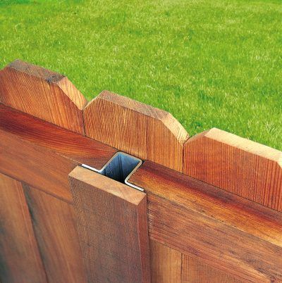 a close up of a wooden fence with grass in the background