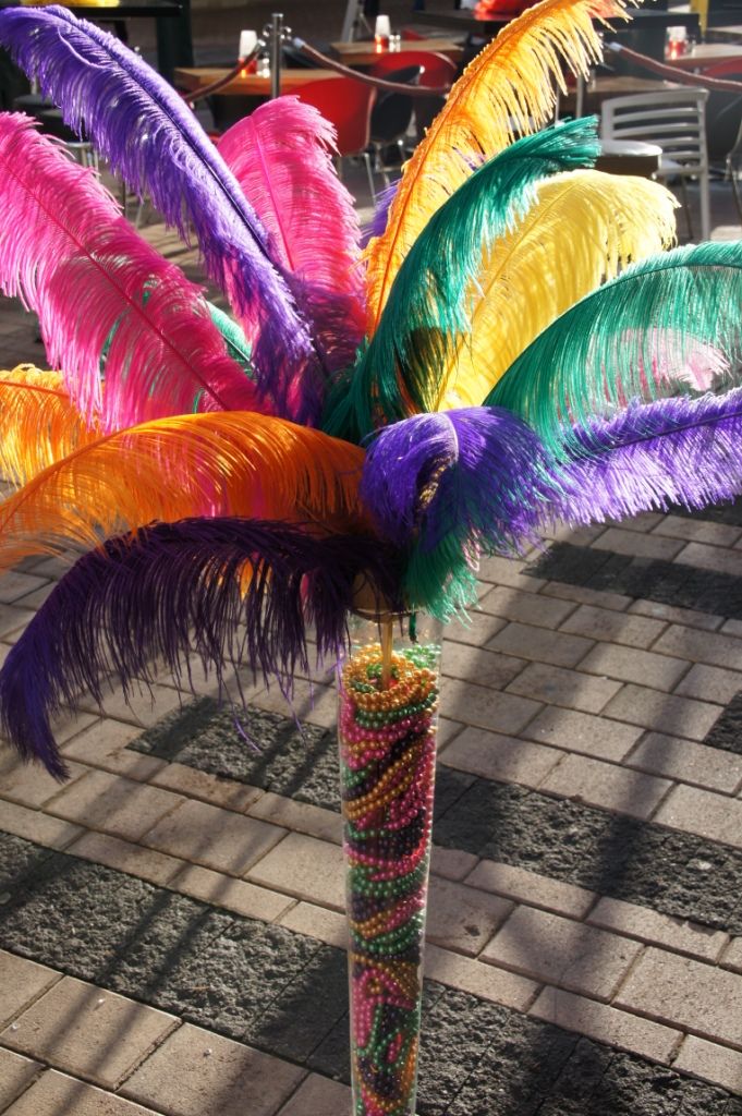 there is a palm tree made out of beads and feathers on the street in front of a restaurant