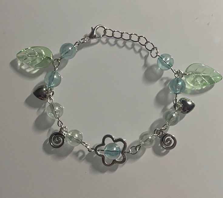 a bracelet with charms and leaves on it