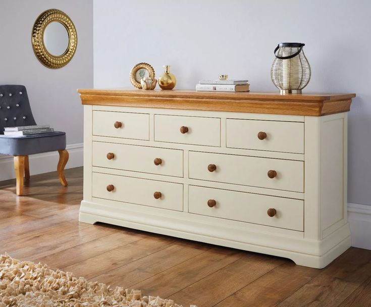 a white dresser with wooden drawers in a room