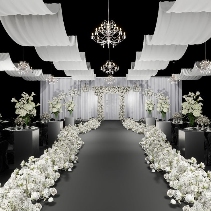 a black and white wedding setup with chandelier, flower arrangements, and draping