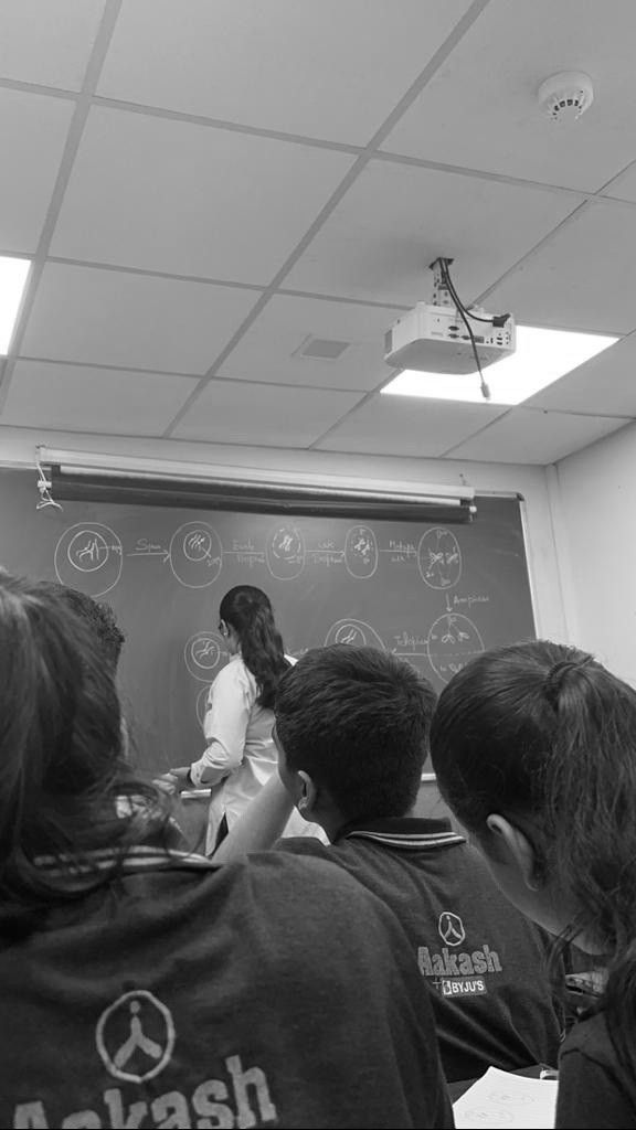 a group of people standing in front of a blackboard