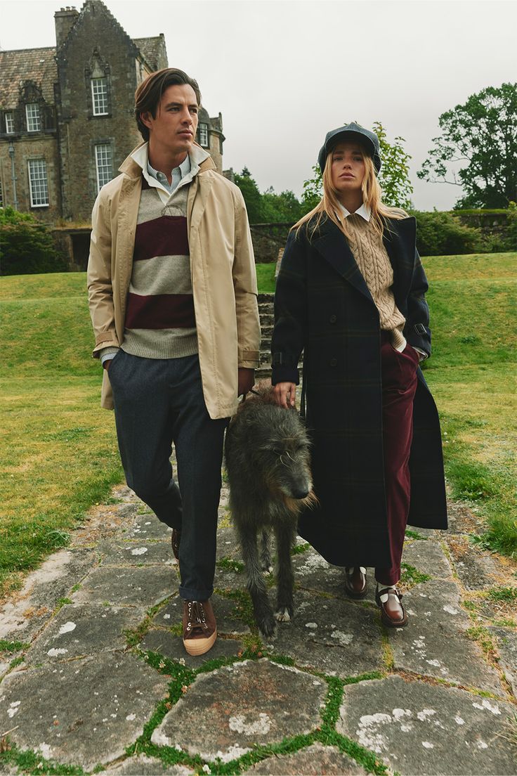 a man and woman standing next to a small animal on top of a stone walkway