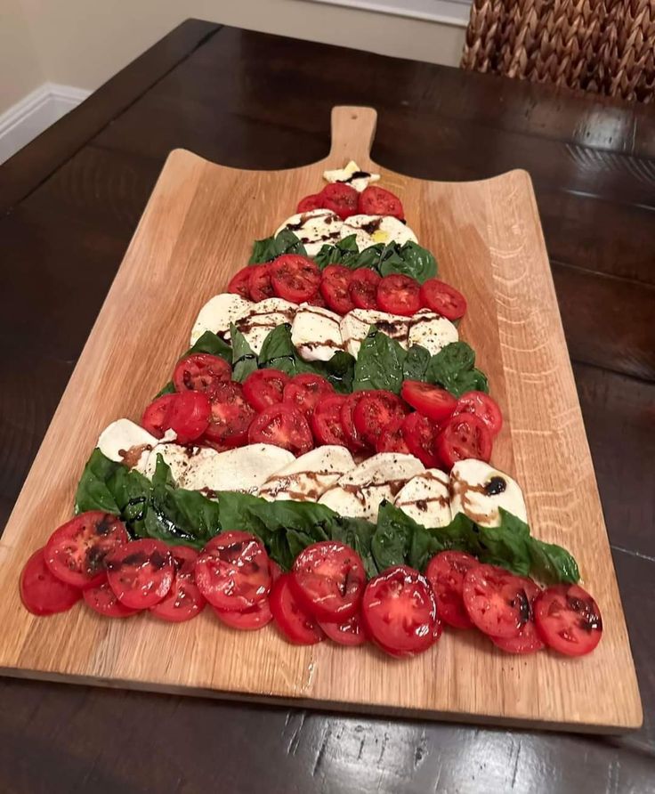 a wooden cutting board topped with tomatoes and cheese