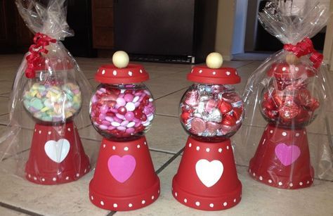 three red candy dispensers with hearts in them on a tile counter top