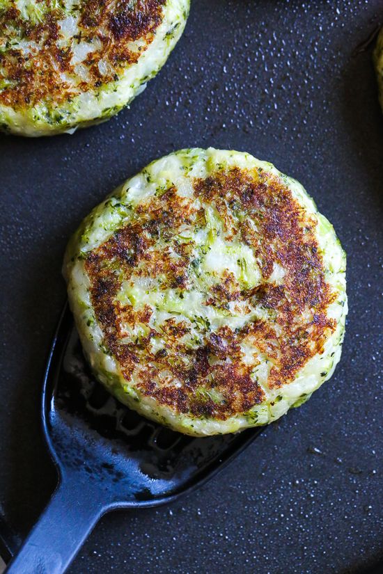 some food that is on top of a black plate with a spatula in it