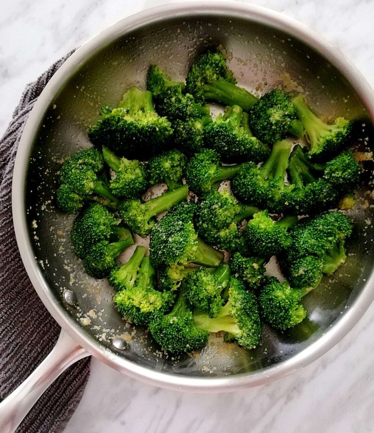 broccoli florets are being cooked in a pan