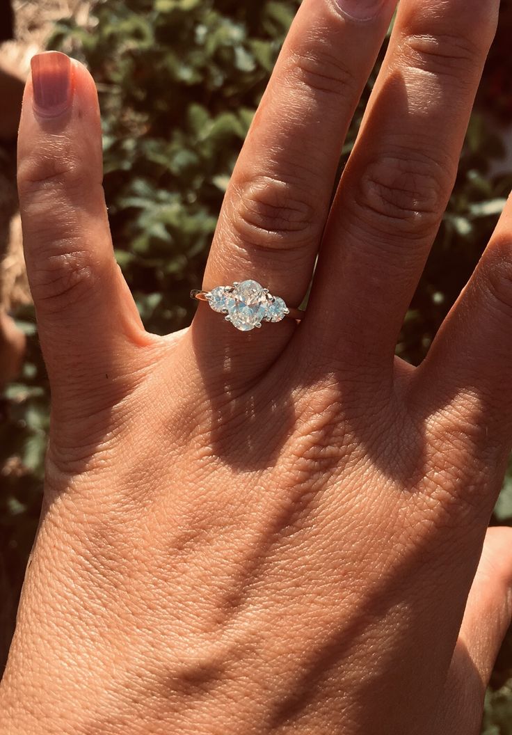 a woman's hand with a diamond ring on it