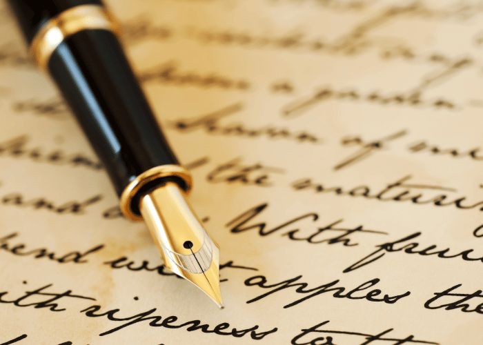 a fountain pen resting on top of an old letter with writing underneath it and the word written in cursive ink