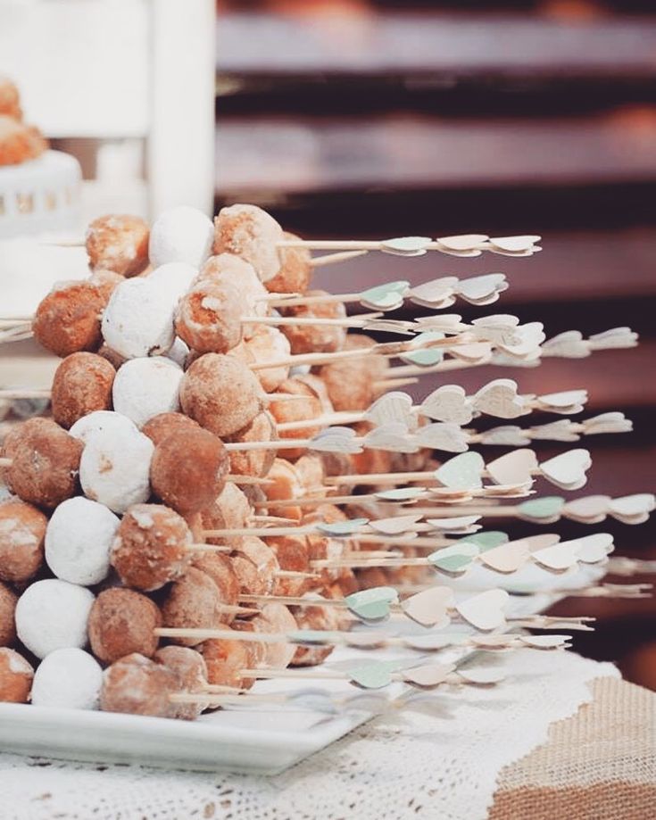 a table topped with lots of donuts and marshmallows on top of skewers