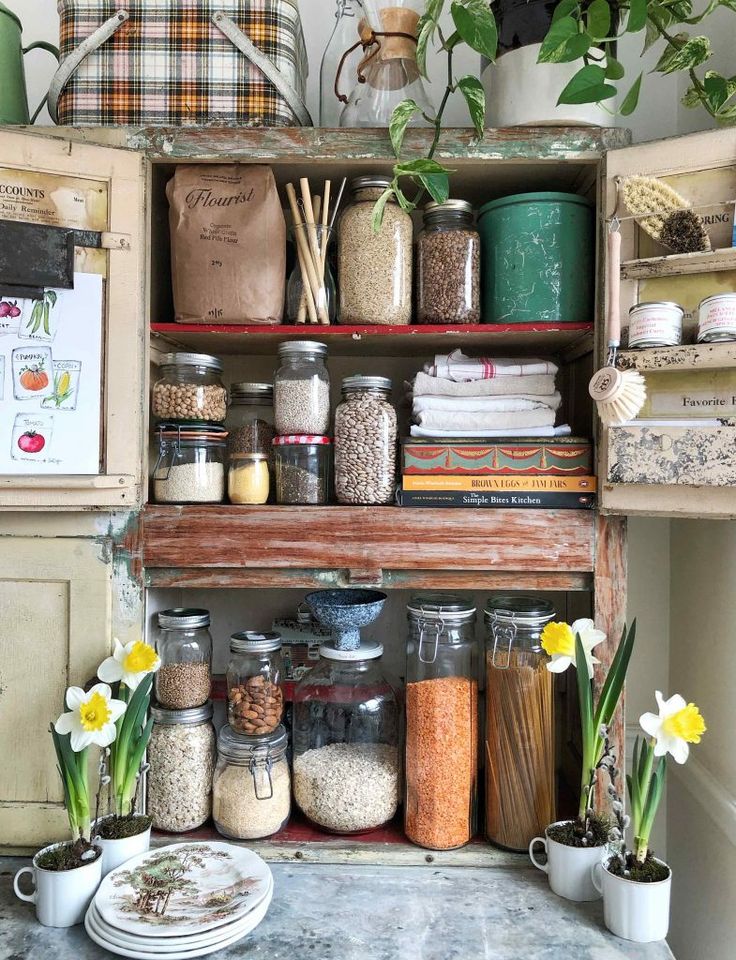 an old cabinet filled with lots of spices and other things on it's shelves