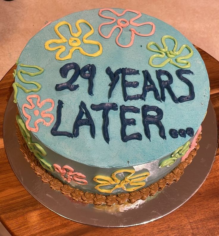 A cake covered in pale blue meringue, with the flowers of spongebob as background, it says "29 years later..." in dark blue letters Cake For 29th Birthday, Funny 29th Birthday Cake, 26 Year Old Birthday Cake Ideas, Birthday 29 Years Party Ideas, 29 Bday Cake, 27 Bday Cake, 29th Birthday Ideas For Her Cake, 30 Year Old Birthday Cake, 29 Cake Birthday