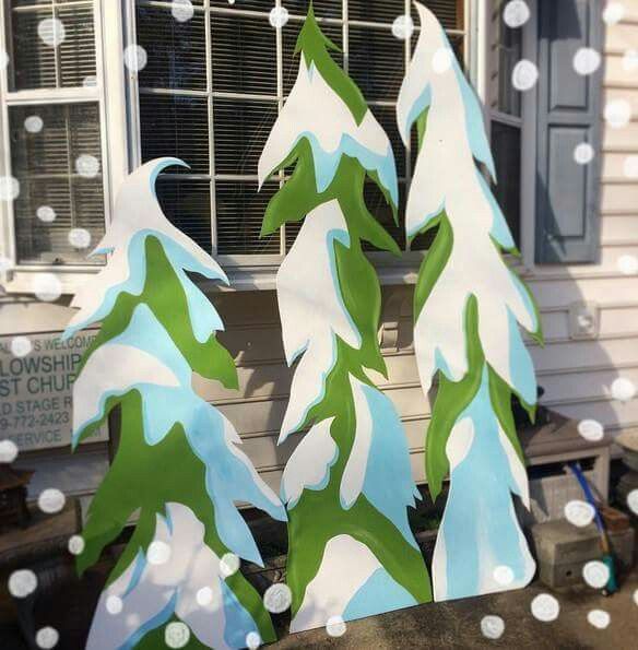 some paper trees are sitting in front of a window with snow falling around them and white dots on the windowsill