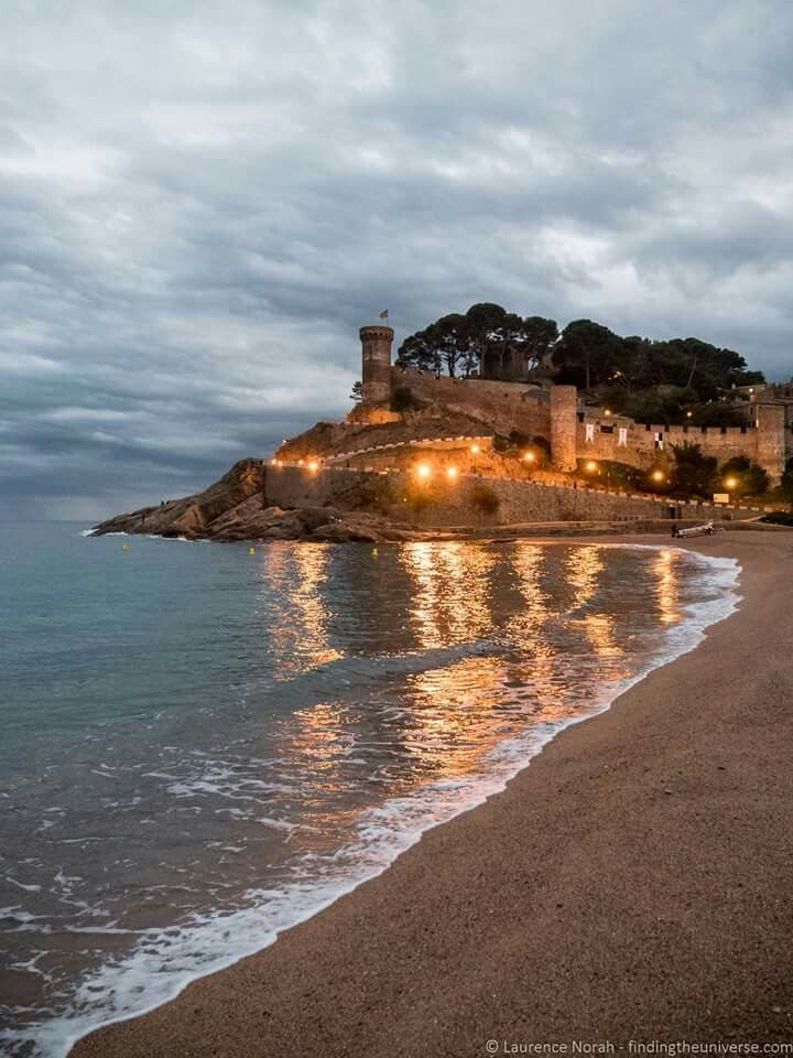 the beach is lit up at night with lights on