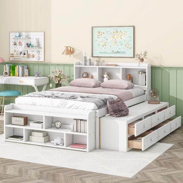 a white bed with drawers underneath it in a green and beige bedroom area, along with other furniture