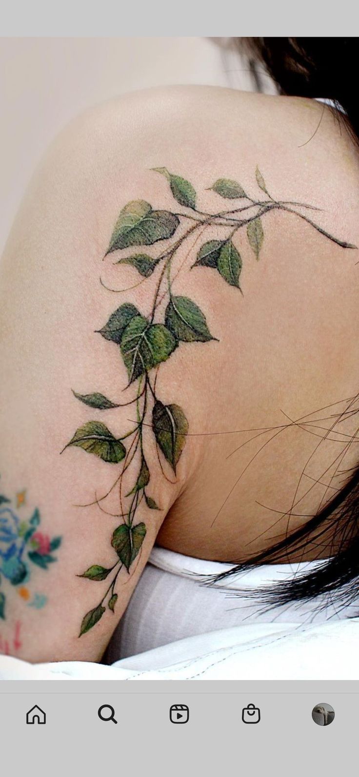 the back of a woman's shoulder with green leaves on it