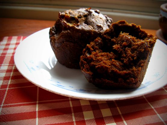 two chocolate muffins on a plate with a red and white checkered tablecloth