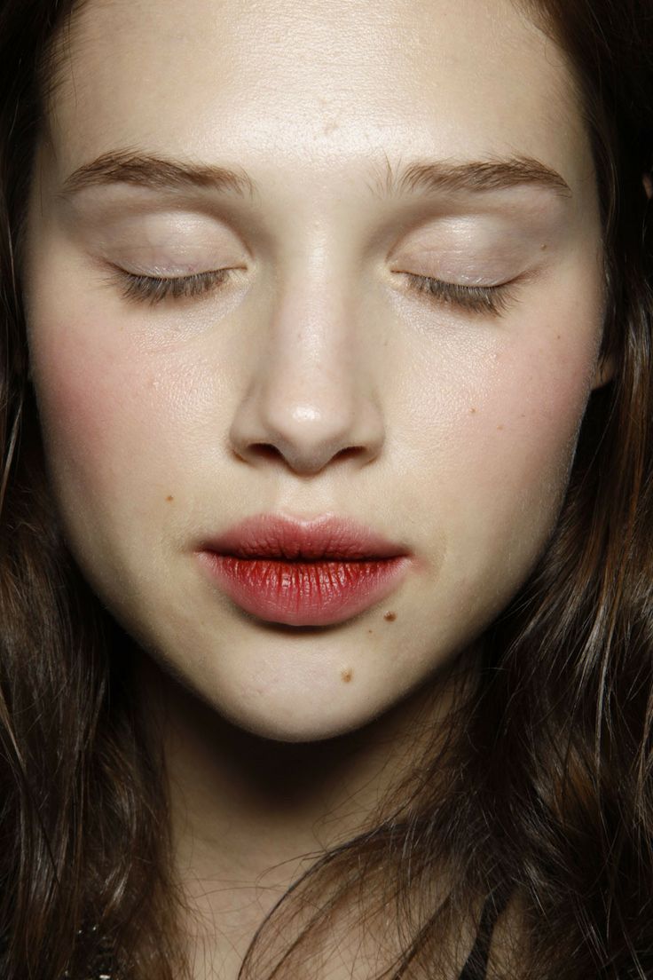 a woman with her eyes closed and long hair in front of her face, wearing red lipstick