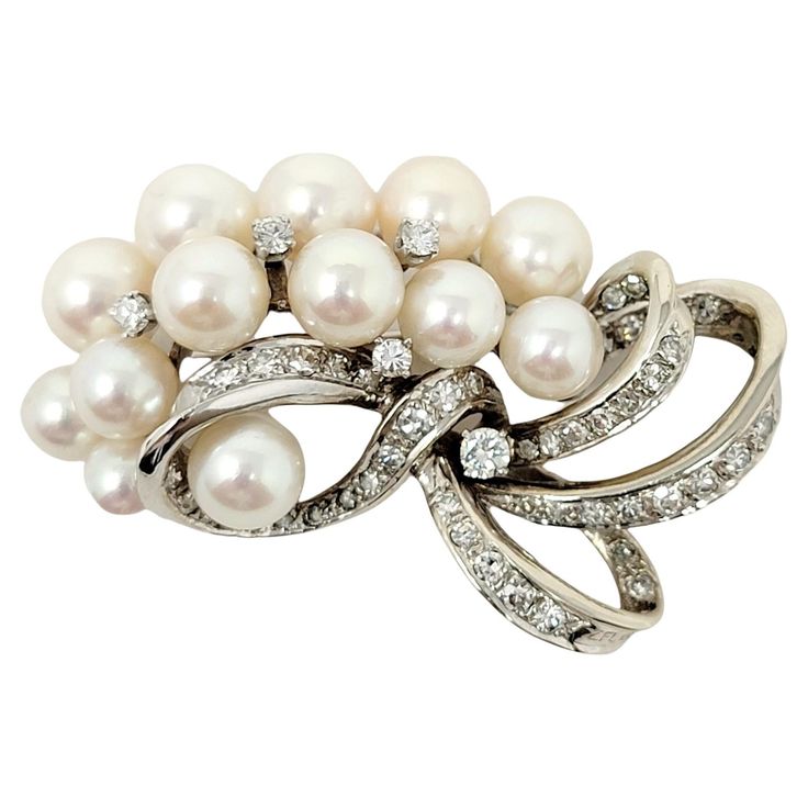 Exquisite vintage style brooch with incredible fine details. This gorgeous brooch is made of 14 karat white gold and arranged in a horizontal layout. The top portion features 2 rows of white cultured pearls, accented by a few single round diamonds. The pearls have a high luster with a lovely rose overtone. The bottom portion is mainly all pave diamonds set in white gold and arranged in a swirling ribbon design. The single cut diamonds are G-H in color, VS-SI in clarity and total 1.70 carats. The Ribbon Design, Tahiti, Diamond Clarity, Cultured Pearls, Pave Diamonds, Vintage Stil, Colored Diamonds, Style Vintage, Round Diamonds