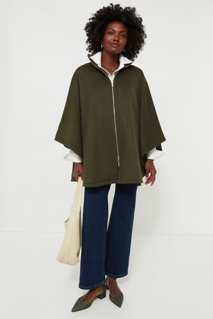 The Olive Full Zip Huntington Cape is a closet must-have for the cold-weather months. The oversized silhouette makes this the perfect layering piece, and the zip closure allows this to be worn on its own or over a button-down. With a wool blend, you are sure to be comfy and cozy in this stylish look- pair with denim and loafers or with a dress and boots for an absolutely elegant outfit. Ribbed stand collar Long poncho sleeves Tonal button at inside of sleeve Gold-tone front zip closure Cape silh Fall Funnel Neck Outerwear With Zipper Closure, Wool Outerwear With Funnel Neck For Fall, Wool Funnel Neck Outerwear For Work, Wool Outerwear With Funnel Neck For Work, Funnel Neck Wool Outerwear For Work, Modern Funnel Neck Winter Outerwear, Modern Funnel Neck Outerwear For Fall, Modern Winter Outerwear With Funnel Neck, Casual Cape For Cold Weather