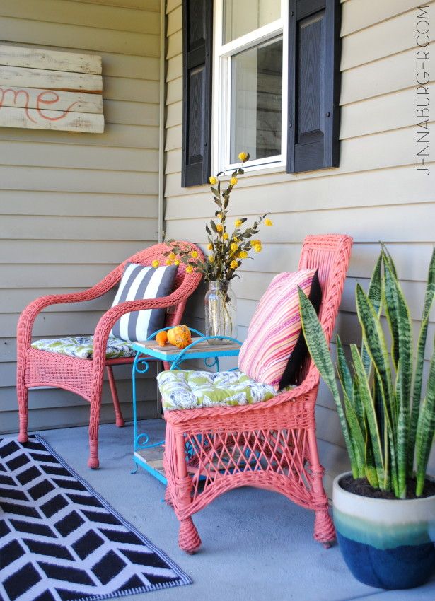 two pink wicker chairs sitting on the front porch