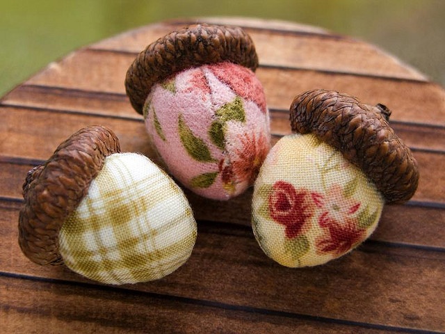 three small stuffed animals sitting on top of a wooden table