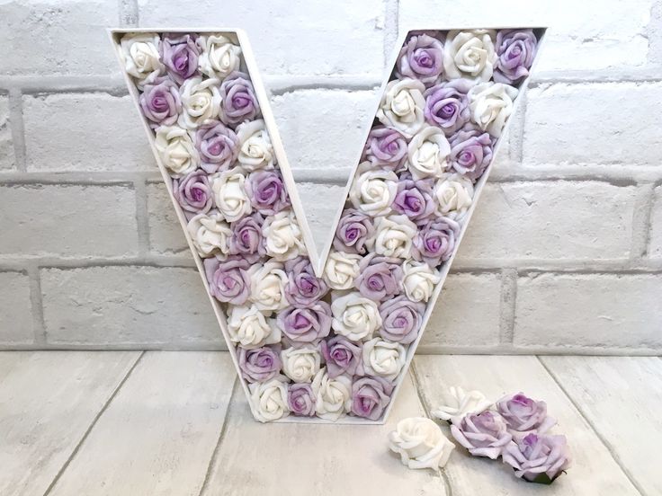 the letter v is made up of purple and white roses