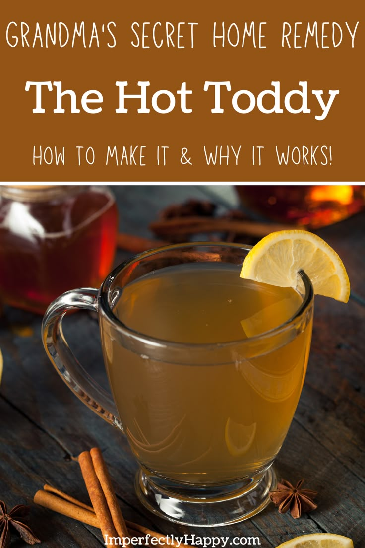 a glass mug filled with liquid next to cinnamons and lemon slices