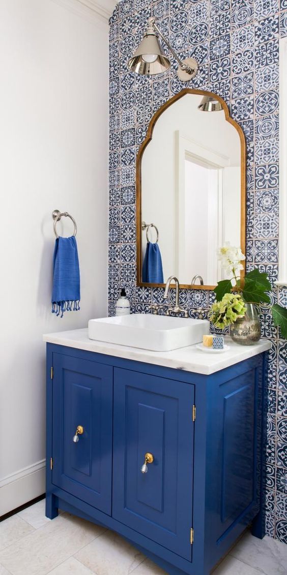 a bathroom with blue cabinets and a mirror