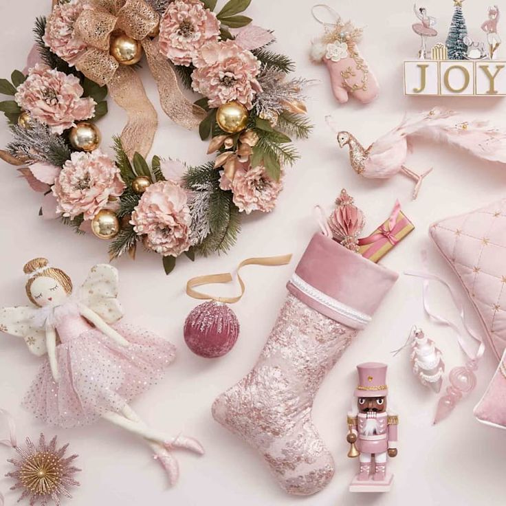 pink christmas decorations and gifts laid out on a white surface