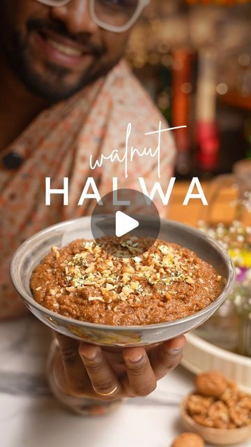 a man holding a plate with food on it and the words walnut hawa in front of him