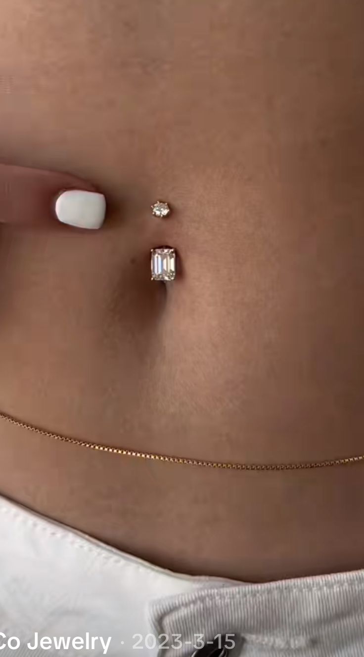 a woman's belly is shown with two small diamonds on the side of her stomach