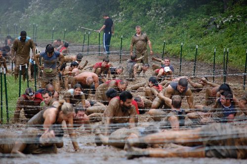 a group of people in mud suits standing around