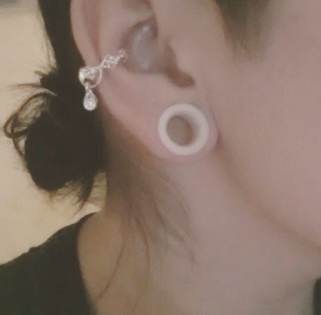 a close up of a person with ear rings on their ears and one behind the ear