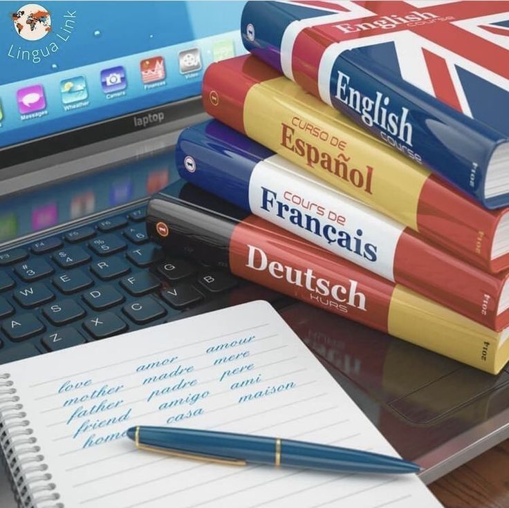 a stack of books sitting on top of a laptop computer next to a pen and notebook