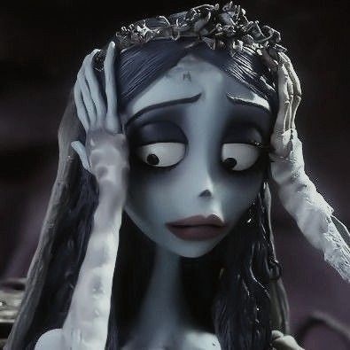 the corpse bride doll is holding her head with one hand and wearing a tiara