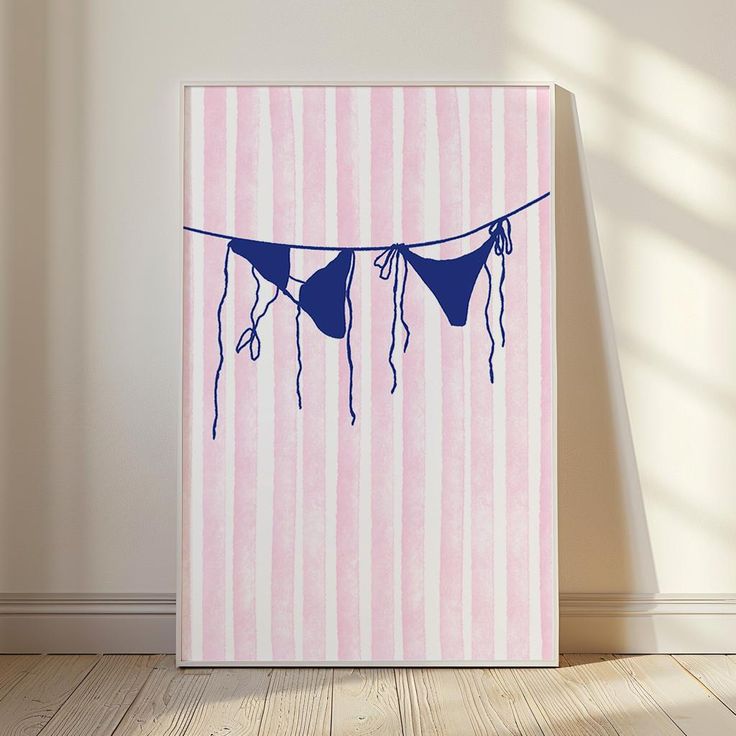 a pink and white striped wall with three blue bikinis hanging from the clothes line