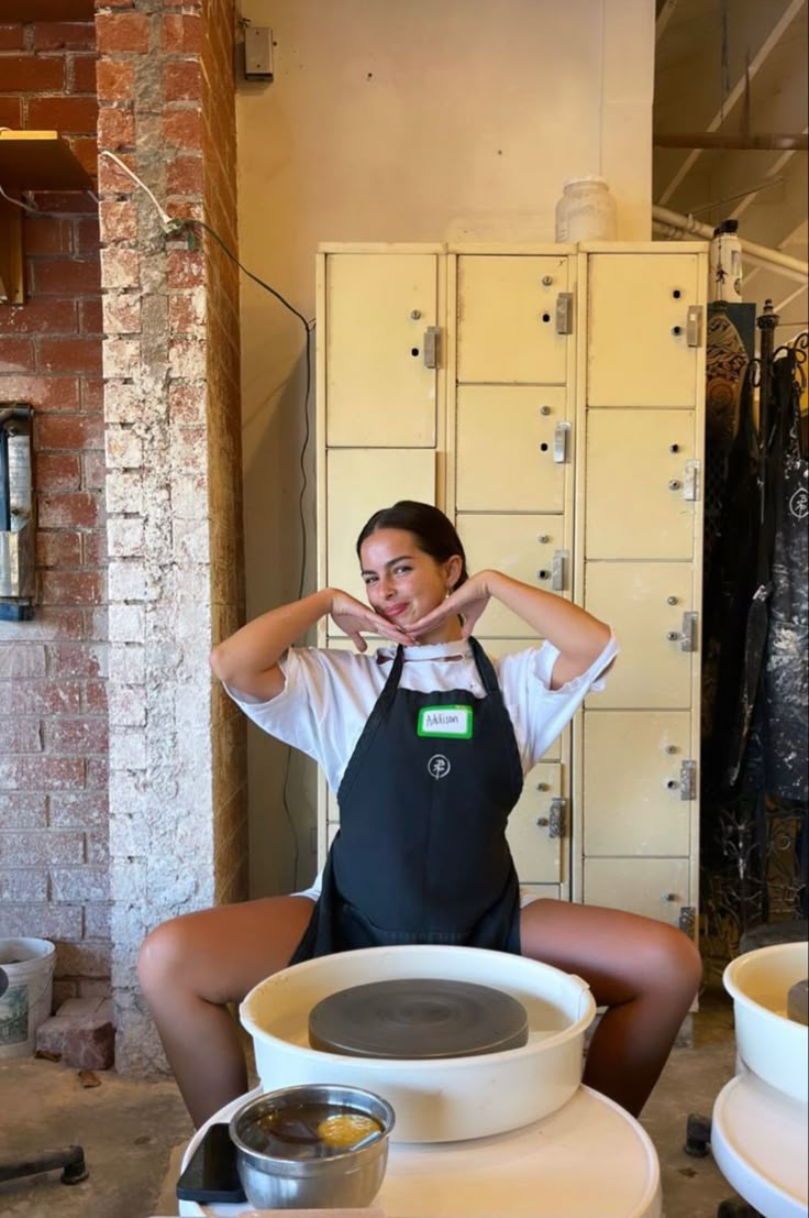 a woman sitting in front of a bunch of lockers with her hands on her head