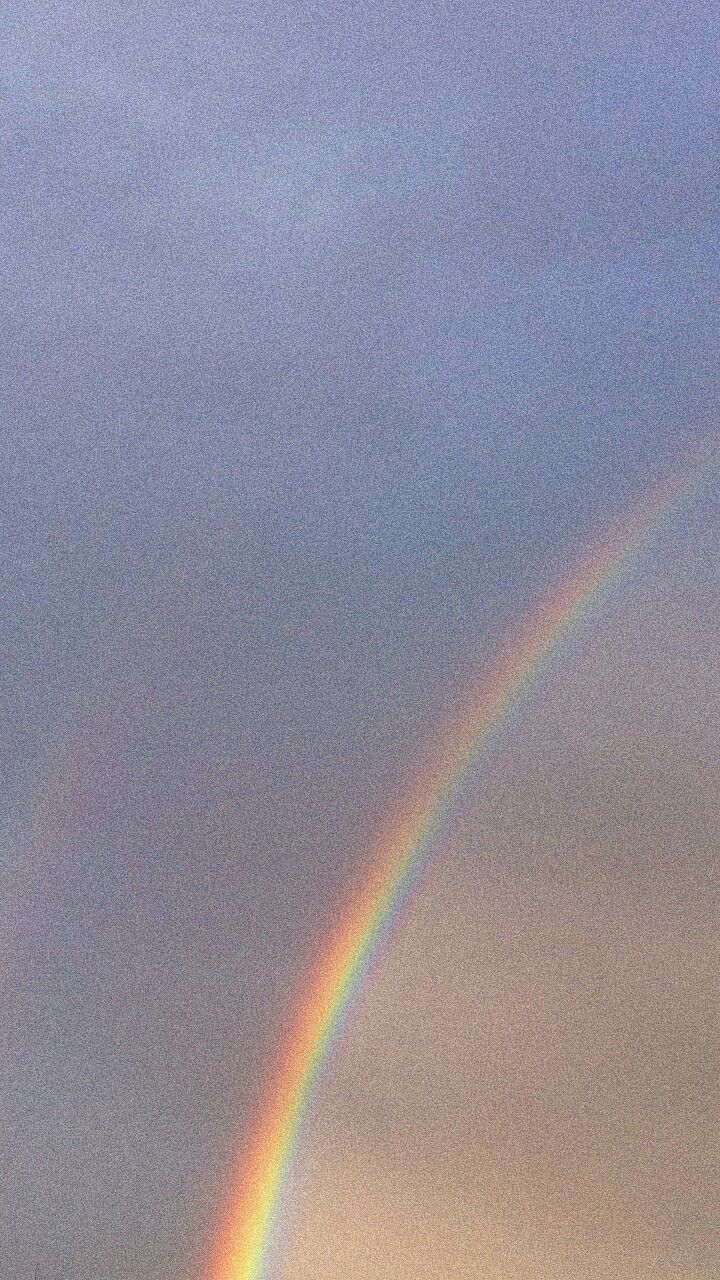 two rainbows are seen in the sky above some trees