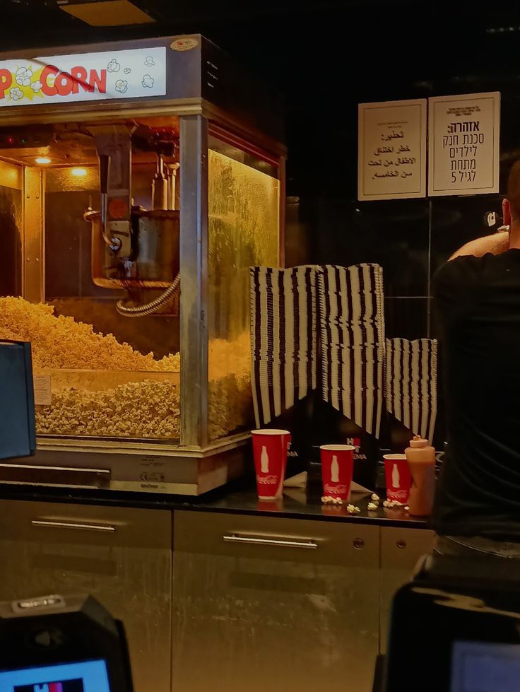 a man standing in front of a popcorn machine